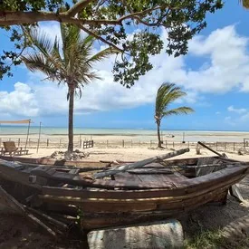 Traditional wooden dhow on a tropical beach in Mozambique